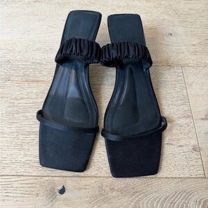 KHAITE Georgia kitten heel slide sandals in black satin.